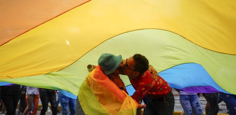 Una pareja se besa mientras participan en el desfile del orgullo gay el domingo 3 de julio de 2022, en Caracas. (AP Foto/Ariana Cubillos)