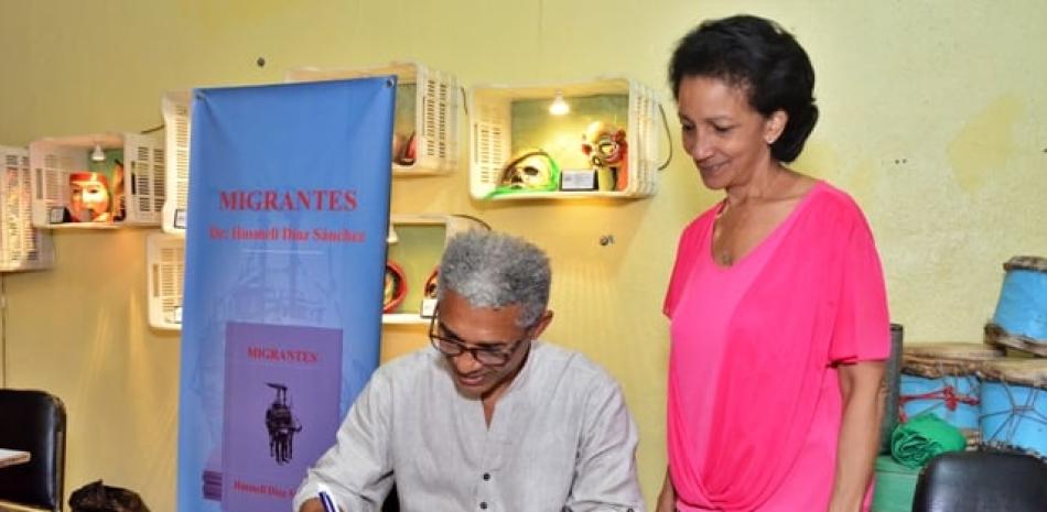Husmell Diaz Sánchez firma un ejemplar de su libro a Onildia Molinete.