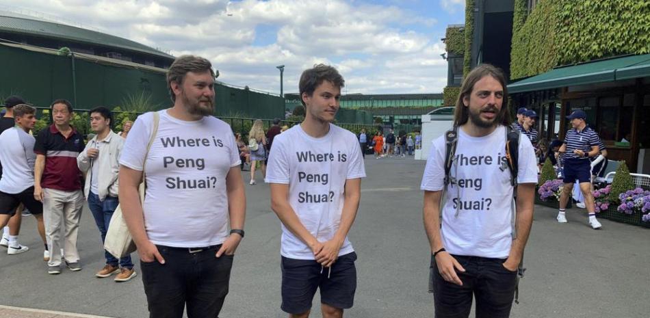 Los activistas Will Hoyles, Caleb Compton y Jason Leith, de la organización Free Tibet portan camisetas que dicen: "¿Dónde está Peng Shuai?" en el torneo de Wimbledon.
