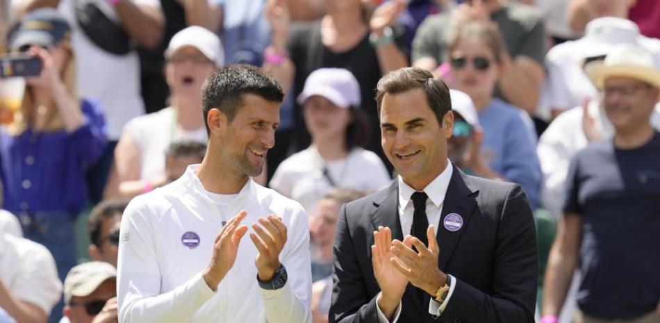 Novak Djokovic y Roger Federer aplauden durante el festejo del centenario de la Cancha Central de Wimbledon.