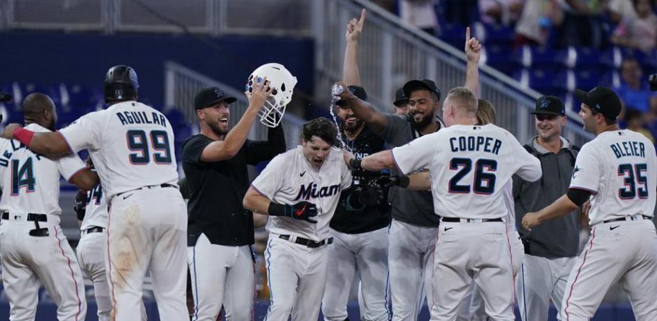 Los compañeros de Brian Anderson de los Marlins se avientan sobre el jugador tras el triple con dos carreras en la 11ma entrada ante los Piratas de Pittsburgh.