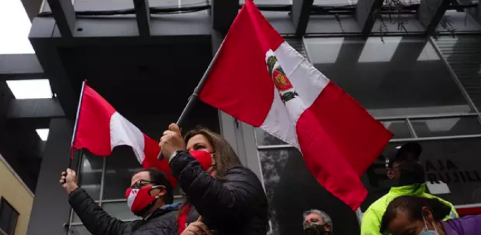 Dos personas onden sendas banderas de Perú. Foto: Europa press