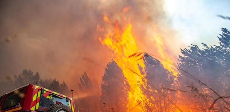 La brigada antiincendios SDIS 33 muestra las llamas consumiendo árboles cerca de Landiras, en el suroeste de Francia, el sábado. AP