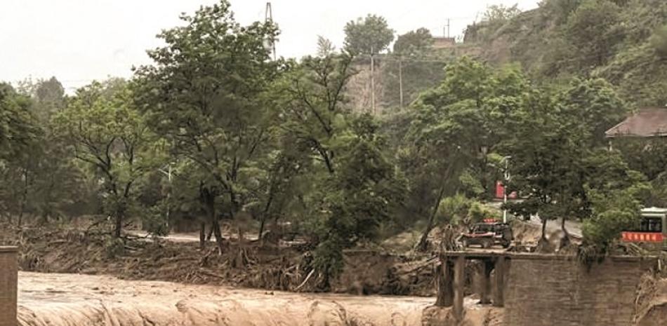 Un vehículo se ve cerca de un puente destruido por las crecidas en un río de Qingyang, en el noroeste de la provincia china de Gansu. AP