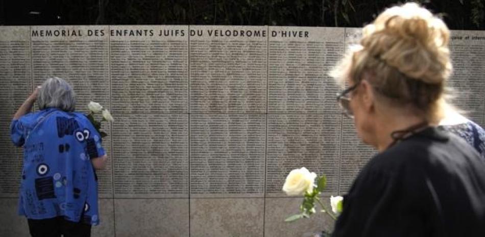 Mujeres depositan flores en el Muro de los Nombres por los 80 años de una redada masiva de judíos en París en 1942.  AP