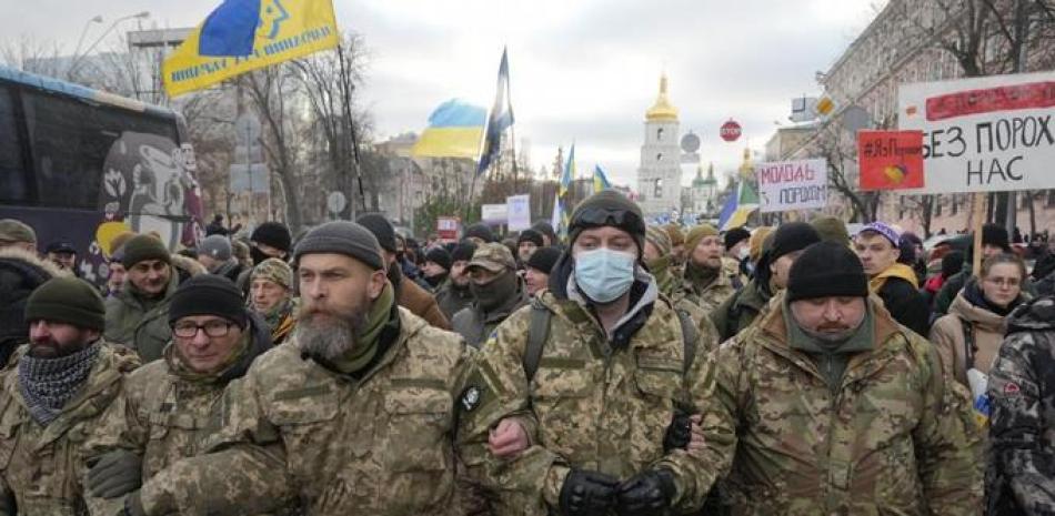 Veteranos de guerra y simpatizantes del expresidente ucraniano Petro Poroshenko se reúnen cerca de un edificio judicial ayer en Kyiv. Un tribunal local debe dictaminar si se debe mantener a Poroshenko bajo custodia por cargos de traición. AP