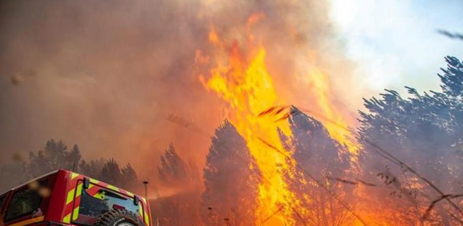 La brigada antiincendios SDIS 33 muestra las llamas consumiendo árboles cerca de Landiras, en el suroeste de Francia, el sábado. AP