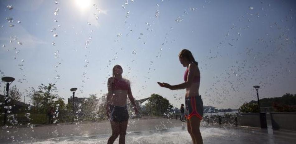 Personas se refrescan en una fuente ante las temperaturas registradas durante una ola de calor, en una fotografía de archivo. EFE