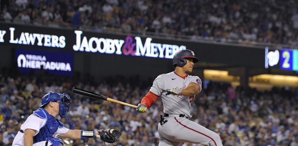 Juan Soto, de los Nacionales de Washington (drecha), batea un triple de dos carreras ante el catcher de los Dodgers de Los Ángeles Will Smith en el quinto inning.