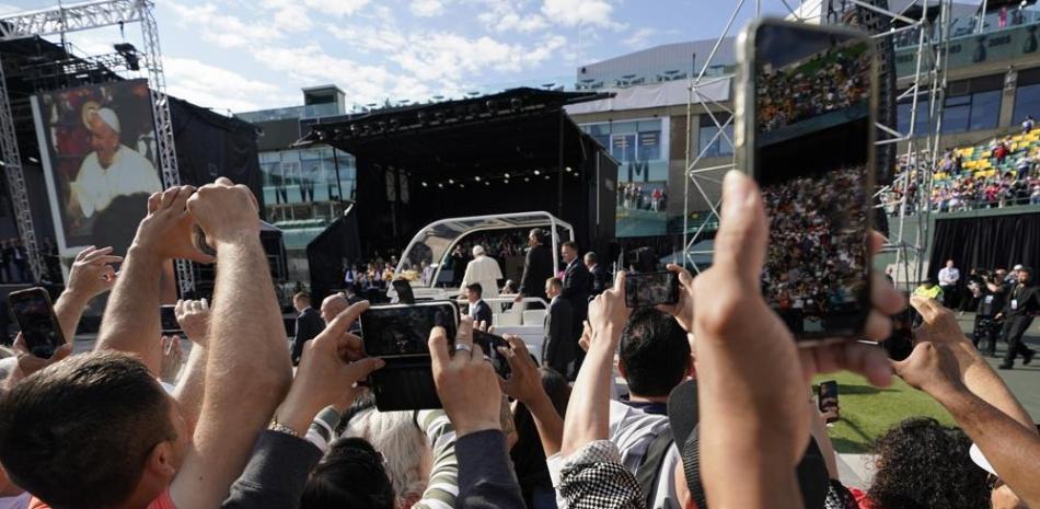 Los fieles usan sus celulares para grabar la llegada del papa Francisco al estadio Commonwealth de Edmonton, Canadá, antes de una misa al aire libre ayer. AP