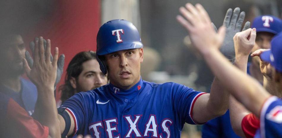 Nathaniel Lowe, de los Rangers de Texas, es felicitado en la cueva luego de pegar un jonrón solitario ante los Angelinos de Los Angeles.