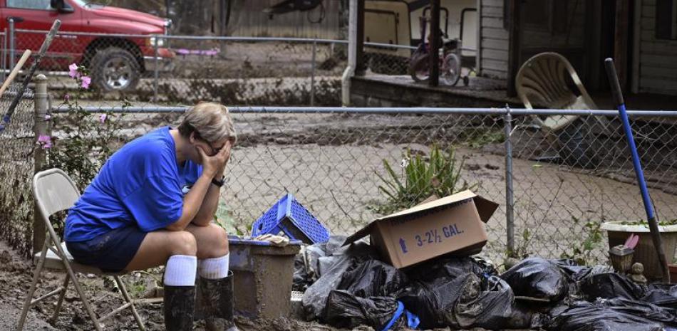 Teresa Reynolds se sienta exhausta mientras miembros de su comunidad despejan los escombros de casas destruidas por inundaciones en Ogden Hollar, Kentucky, el 30 de julio del 2022.