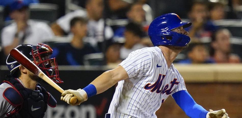 Tyler Naquin, de los Mets de Nueva York, observa la pelota al conectar un jonrón en el sexto inning del encuentro ante los Bravos de Atlanta.