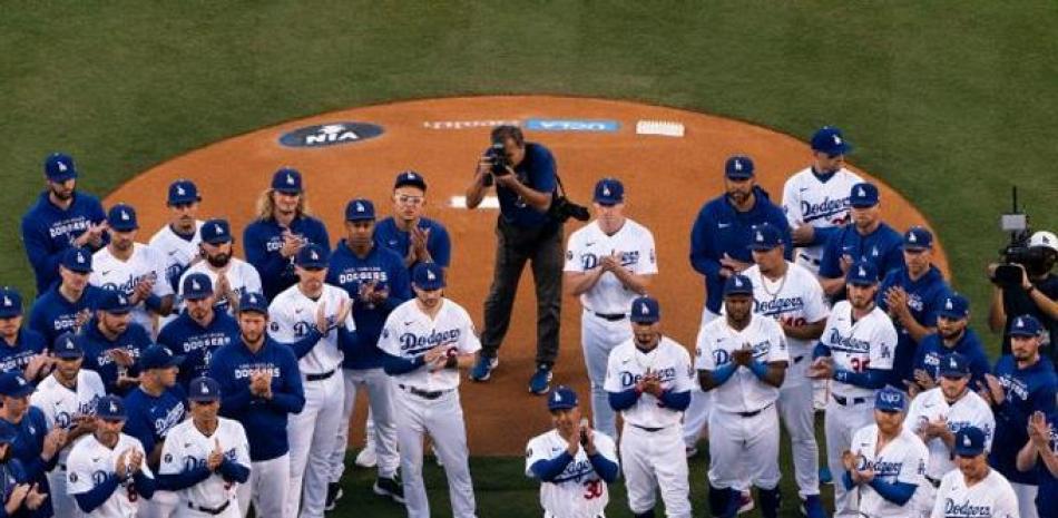Integrantes de los Dodgers aplauden durante el homenaje rendido por el equipo a su ícono y extindo narrador Vin Scully