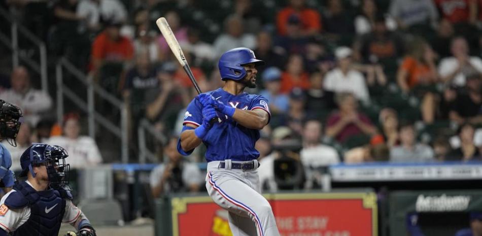 El dominicano Leody Taveras, de los Rangers de Texas, batea un doble de tres carreras delante del receptor boricua Christian Vázquez, de los Astros de Houston.