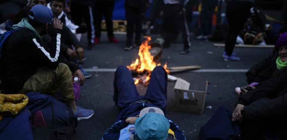 Un manifestante yace ayer en una calle en medio de una carretera que bloquea una importante avenida en el centro de Buenos Aires, Argentina, AP
