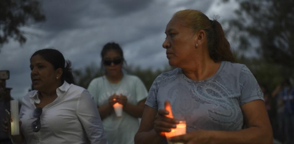 Los familiares sostienen velas durante una vigilia mientras los rescatistas participan en una operación que intenta llegar a 10 mineros atrapados en una mina de carbón inundada luego de un deslizamiento de tierra, en la comunidad de Agujita, Municipio de Sabinas, Estado de Coahuila, México, el 11 de agosto de 2022. Pedro PARDO / AFP