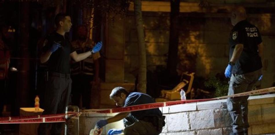 Investigadores examinan el lugar donde ocho israelíes resultaron heridos durante un ataque a tiros contra un autobús cerca de la Ciudad Vieja de Jerusalén. AP