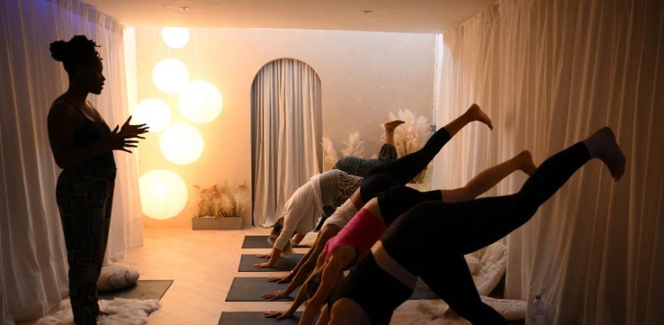 La profesora de yoga y autora Stacie Graham da una sesión de yoga en el estudio "She's lost control" en el este de Londres, el 14 de julio de 2022. AFP.