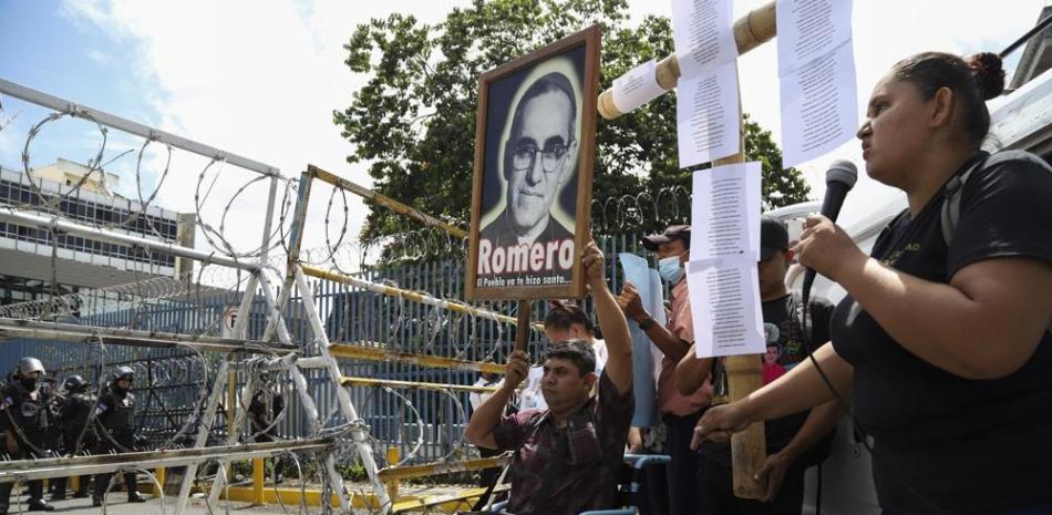Un manifestante en silla de ruedas levanta una imagen del asesinado Monseñor Oscar Arnulfo Romero (1917-1980), durante una protesta frente a la Asamblea Legislativa en San Salvador, el martes 16 de agosto de 2022. AP