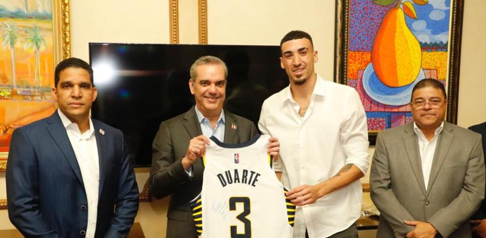 El presidente Luis Abinader recibe del jugador dominicano de la NBA Chris Duarte una camiseta de los Pacers de Indiana, en la visita que le hizo en el Palacio Nacional. Le acompañan, Rafael Uribe y Francisco Camacho.