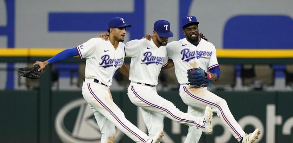De izquierda a derecha, Bubba Thompson, Leody Taveras y Adolis García, festejan un triunfo de los Rangers de Texas sobre los Atléticos de Oakland.