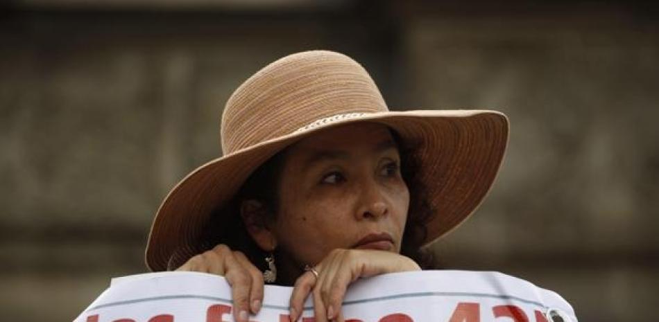 Una mujer lleva una pancarta que hace referencia a los 43 estudiantes desaparecidos de una escuela rural de maestros, durante una marcha el jueves 26 de noviembre de 2015, en la Ciudad de México. AP
