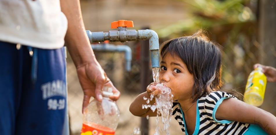 Una niña bebe agua del grifo al aire libre en Vietnam. Según Unicef, 750 millones de personas en todo el mundo carecen de acceso directo al agua potable. ISTOCK/ARCHIVO