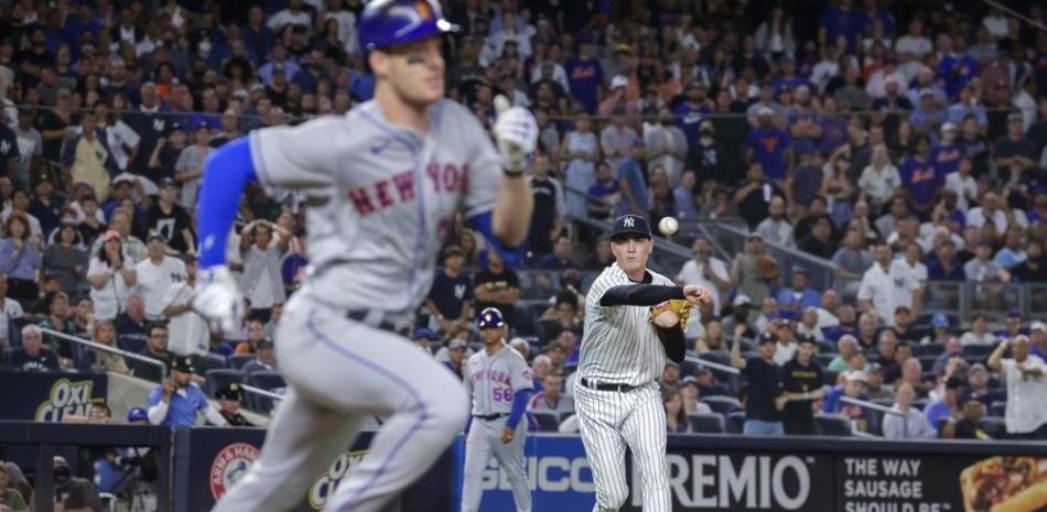 El relevista de los Yanquis de Nueva York, Ron Marinaccio, al centro, pone out a Mark Canha, de los Mets de Nueva York,  en la séptima entrada del partido.