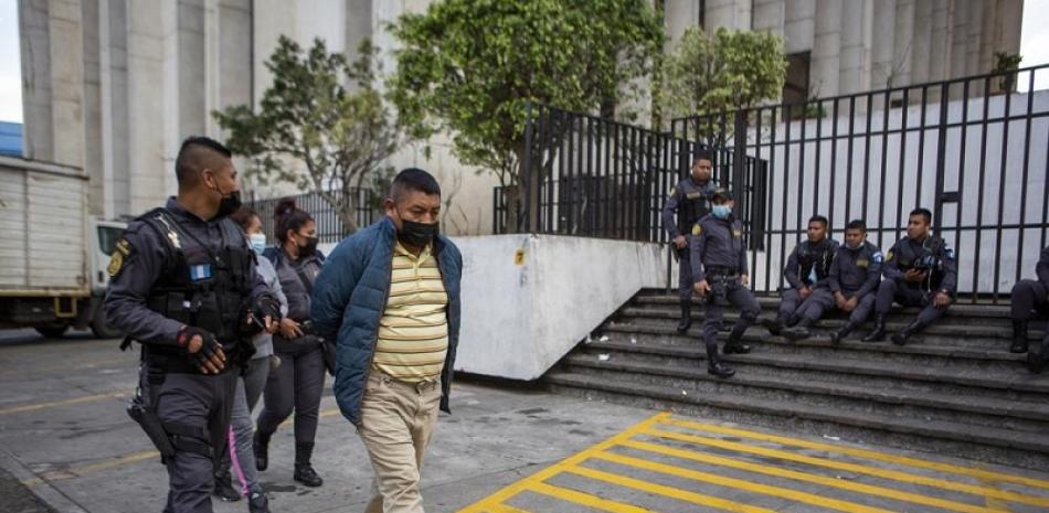David Coronado Perez, acusado de pertenecer a una banda de traficantes, es escoltado por la policía tras una audiencia judicial en la Ciudad de Guatemala el 4 de febrero del 2022. Su abogado dice que es un campesino, no un traficante.