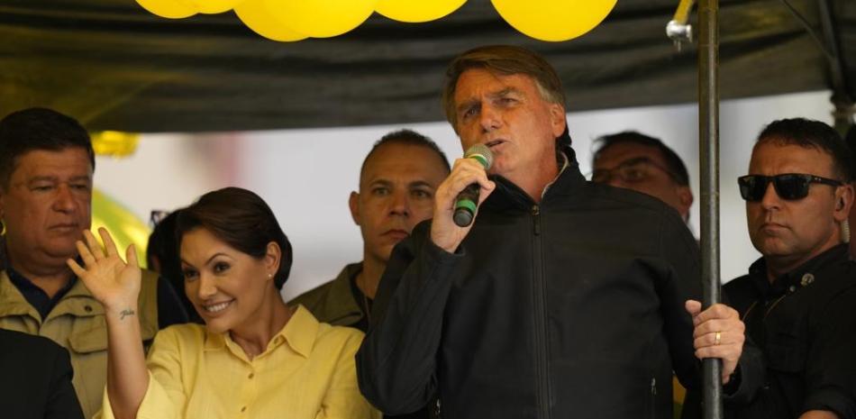 El presidente Jair Bolsonaro habla durante un mitin de campaña mientras su esposa Michelle saluda, en Juiz de Fora, estado de Minas Gerais, el 16 de agosto de 2022. ap