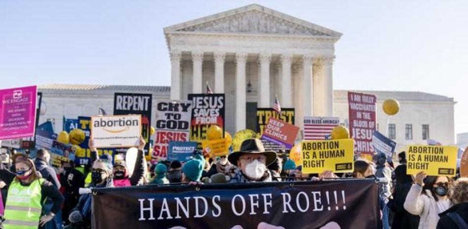 Stephen Parlato de Boulder, Colorado, sostiene un cartel que dice “¡¡¡Manos fuera de Roe!!!” durante manifestaciones en pro y en contra del aborto, en Washington. ap