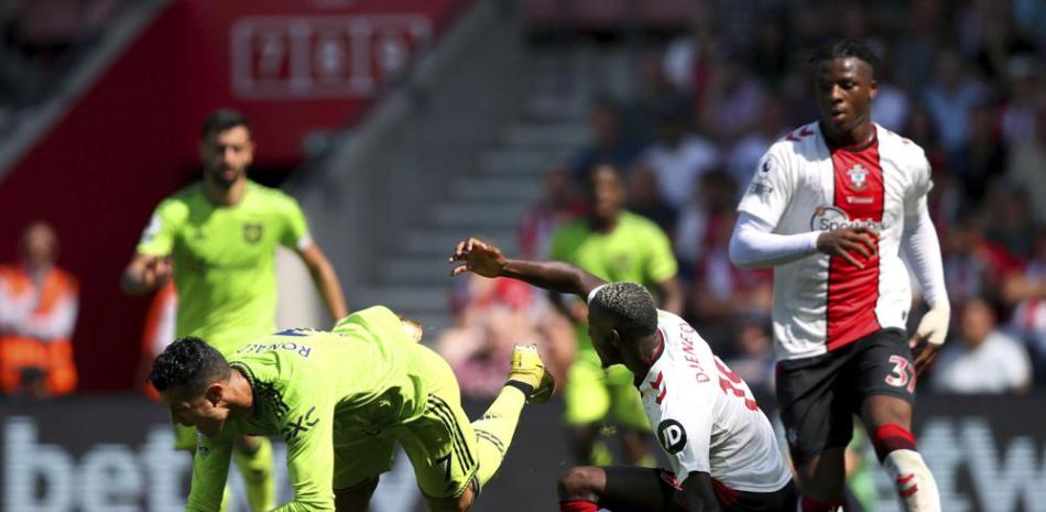 Moussa Djenepo del Southampton' derecha, derriba a Cristiano Ronaldo del Manchester United en partido de la Liga Premier en el St Mary's Stadium.