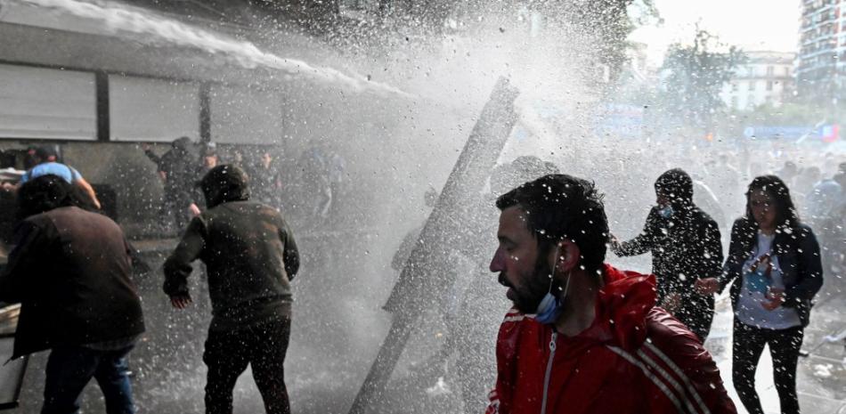 Los partidarios de la vicepresidenta argentina Cristina Fernández de Kirchner que realizan una manifestación cerca de su casa son dispersados por un cañón de agua de la policía antidisturbios en Buenos Aires, el 27 de agosto de 2022.
Luis ROBAYO / AFP