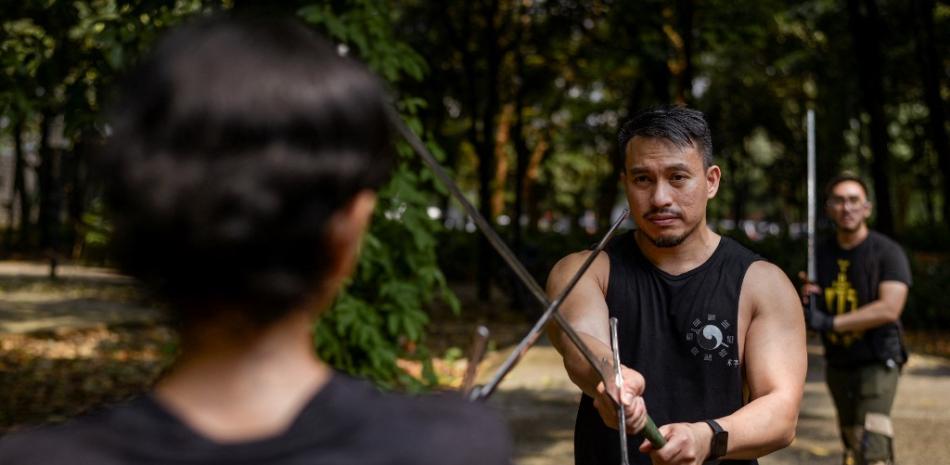 Esta fotografía tomada el 24 de julio de 2022 muestra a miembros del grupo Gwaith-i-Megyr practicando técnicas de lucha con espada conocidas como Artes Marciales Históricas Europeas (HEMA) en un parque en Yakarta. 
BAHÍA ISMOYO / AFP