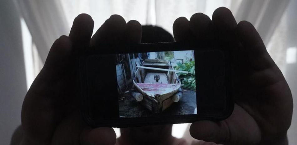 Un migrante cubano que pidió no ser identificado por temores a la seguridad de su familia que vive en la isla, muestra una foto del bote rudimentario que él mismo fabricó para salir de Cuba junto a tres amigos. ap