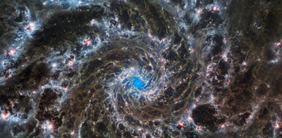 Esta imagen compuesta publicada por la NASA/ESA el 30 de agosto de 2022 desde el Telescopio Espacial James Webb y el Telescopio Espacial Hubble muestra el corazón de M74, también conocida como la Galaxia Fantasma. M74, una galaxia espiral a 32 millones de años luz de distancia, está compuesta por alrededor de 100 mil millones de estrellas. Folleto / NASA/ESA / AFP