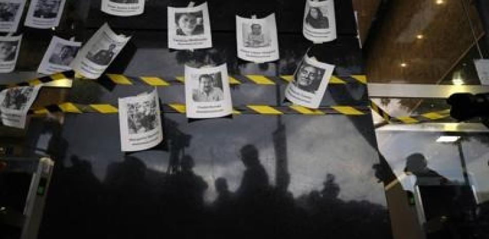 Fotos de periodistas asesinados, colocadas sobre una pared durante una vigilia para protestar por la muerte del reportero Fredid Román ap