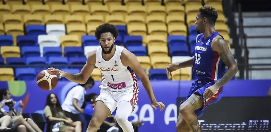 George Conditt, de Puerto Rico, maneja el balón ante la defensa de Jeromy Rodríguez, de República Dominicana, en el partido de la FIBAAmericup en Recife, Brasil.