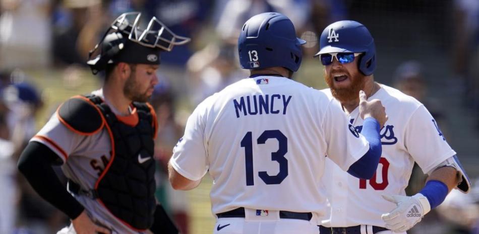 Justin Turner celebra con Max Muncy, su compañero de los Dodgers de Los Ángeles, luego de conectar un jonrón ante los Gigantes de San Francisco.