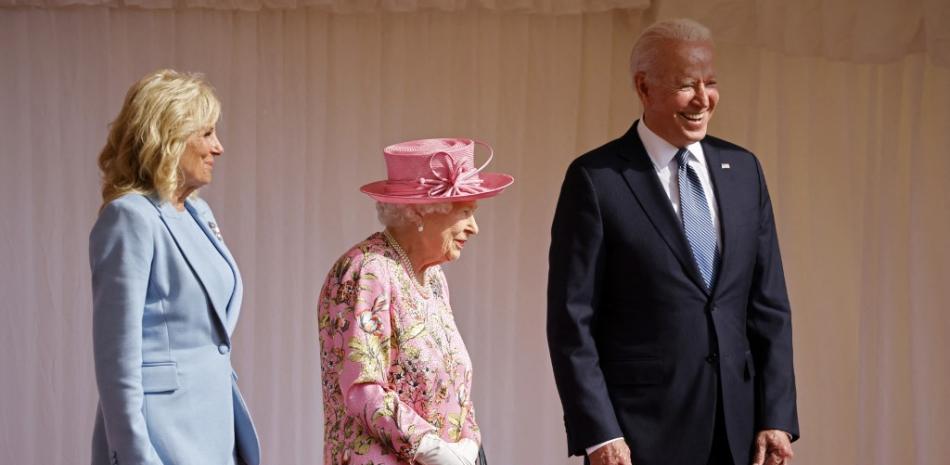 En esta foto de archivo tomada el 13 de junio de 2021, el presidente de EE.UU., Joe Biden (d), y la primera dama de EE.UU., Jill Biden (i), comparten una broma con la reina Isabel II de Gran Bretaña (c) antes de ver el desfile militar en el castillo de Windsor, al oeste de Londres. Foto: Tolga Akmen/AFP.