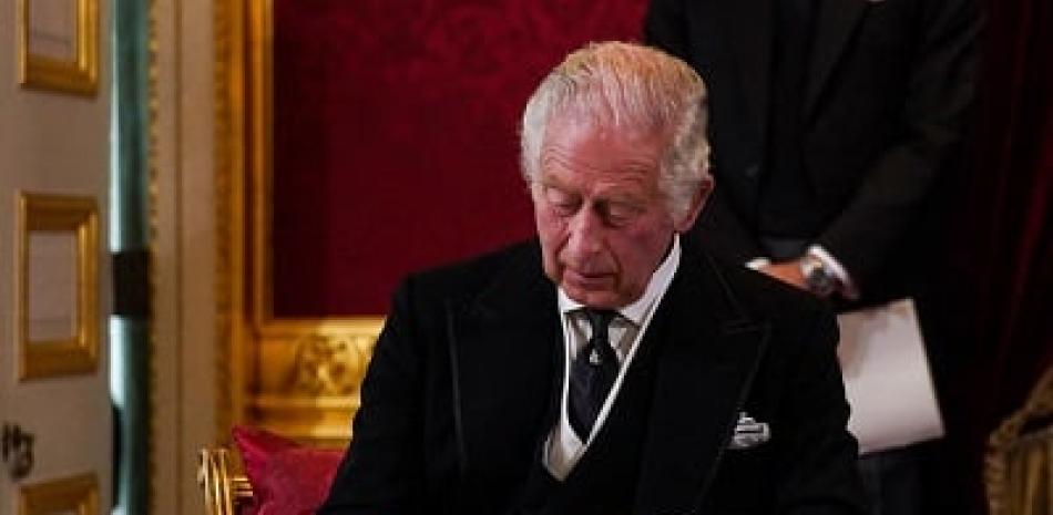 El rey Carlos III de Gran Bretaña firma un juramento para defender la seguridad de la Iglesia en Escocia, durante una reunión del Consejo de Adhesión dentro del Palacio de St James en Londres. Foto: AFP Forum.