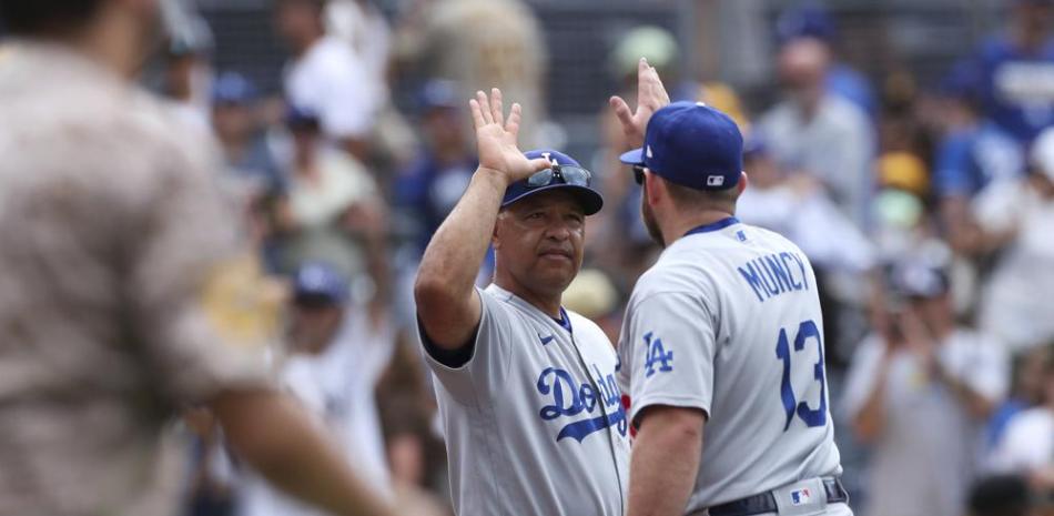 El manager de los Dodgers de Los Ángeles, Dave Roberts, a la izquierda, felicita a Max Muncy después de la victoria del domingo.