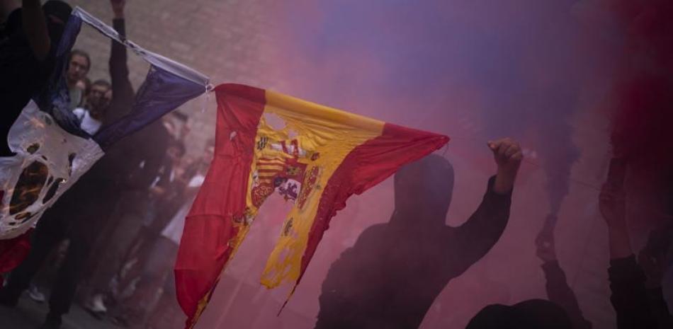 Manifestantes queman una bandera española. AP