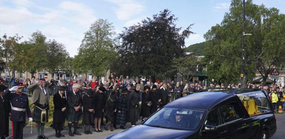 Ciudadanos en Ballater, Escocia, al paso del auto fúnebre de la reina Isabel II en su recorrido desde Balmoral a Edimburgo, en Escocia, el sábado 11 de septiembre de 2022. ap