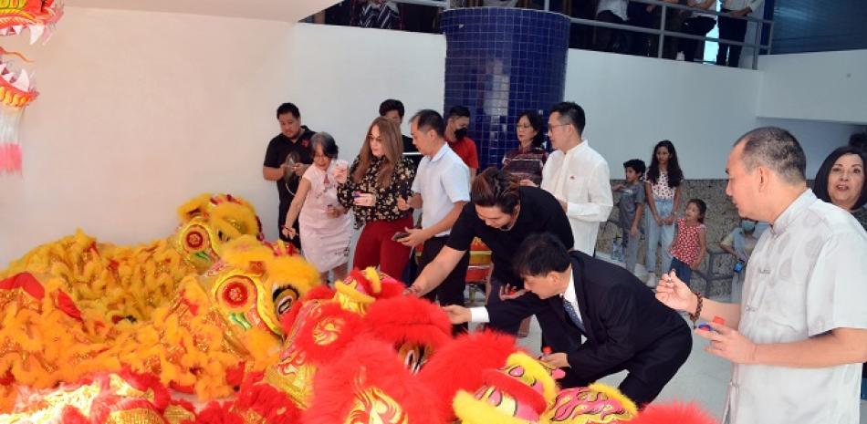 Directivos de  Jade y de la embajada de la Republica Popular china pintan la cara de los leones y dragones.