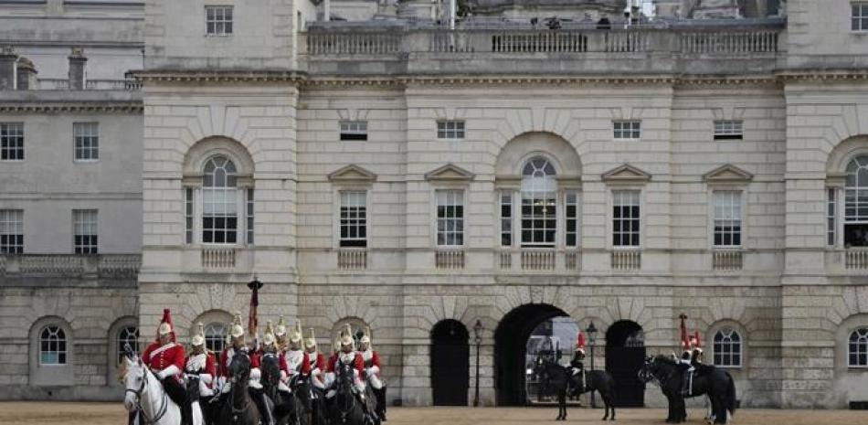 Miembros de los Life Guards, una unidad de la Household Cavalry, comienzan a prepararse en el centro de Londres el 14 de septiembre de 2022, antes de la procesión ceremonial del féretro de la reina Isabel II, desde el Palacio de Buckingham hasta Westminster Hall. Foto: Alastair Grant/AFP.