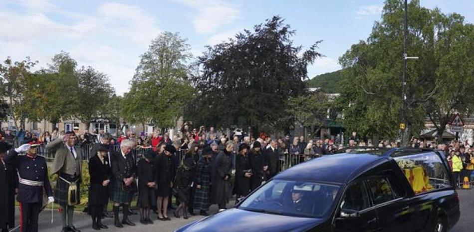 Ciudadanos en Ballater, Escocia, al paso del auto fúnebre de la reina Isabel II en su recorrido desde Balmoral a Edimburgo, en Escocia, el sábado 11 de septiembre de 2022. AP