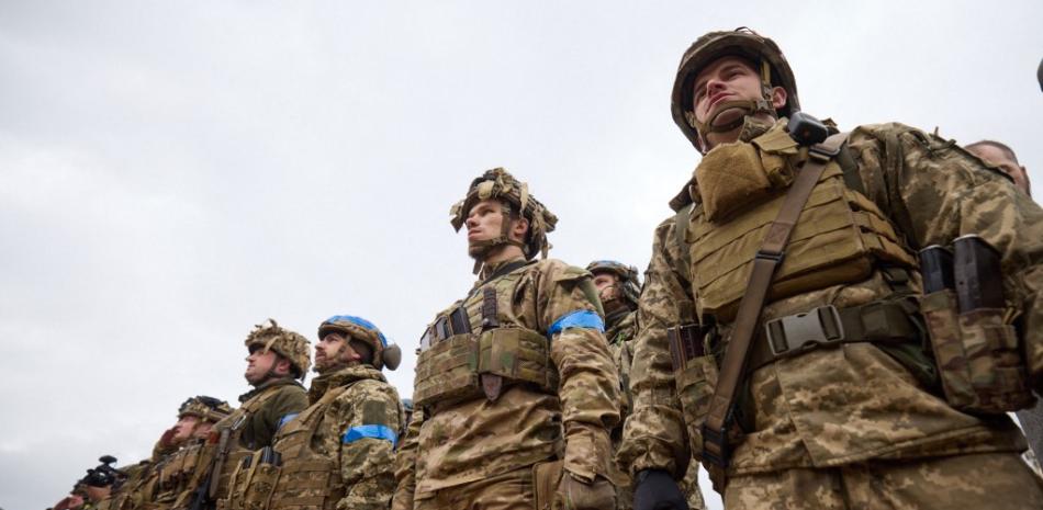 Esta fotografía tomada y publicada por el servicio de prensa presidencial de Ucrania el 14 de septiembre de 2022 muestra a los militares ucranianos participando en la ceremonia de izamiento de la bandera del estado en presencia del presidente ucraniano en la ciudad desocupada de Izyum, región de Kharkiv. STR / Servicio de prensa presidencial de Ucrania / AFP