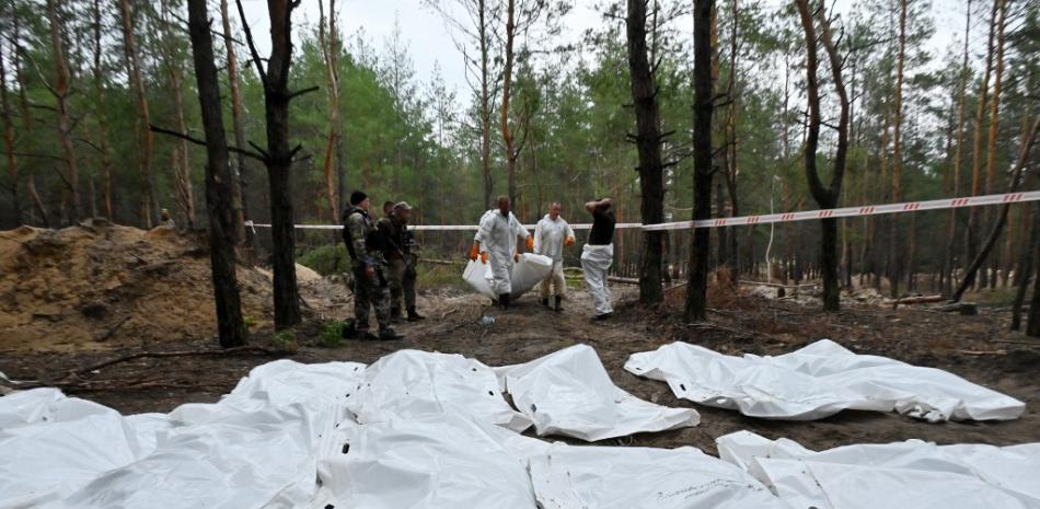 Los técnicos forenses cavan una tumba en un bosque en las afueras de Izyum, en el este de Ucrania, el 16 de septiembre de 2022. Ucrania dijo el 16 de septiembre de 2022 que había contado 450 tumbas en un solo sitio de entierro cerca de Izyum después de recuperar la ciudad del este de los rusos.

SERGEY BOBOK / AFP
